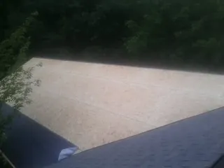 New OSB roof sheathing installed beside an existing shingle roof in Marshall